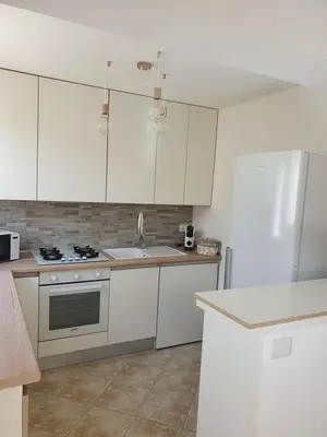 a kitchen with white cabinets and a sink at Dancing Apartment in Castelluzzo