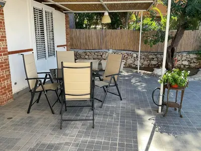 a patio with a table and chairs on a patio at la Casetta di Laura in Terrasini