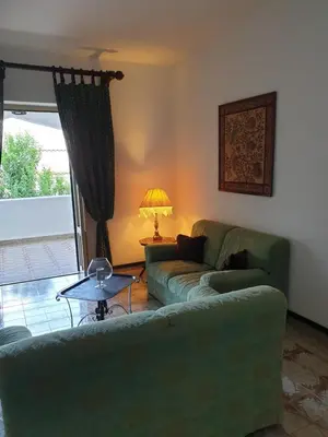 a living room with a green couch and a table at Casa Delizia in Lido di Mondello