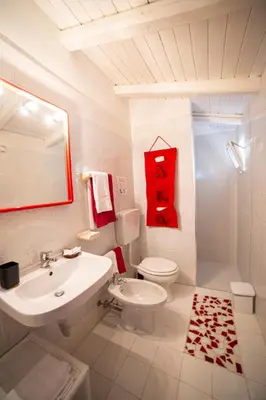 a white bathroom with a sink and a toilet at Le Yucche in Partinico