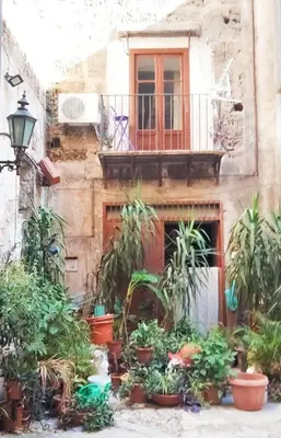 a building with potted plants in front of a building at Casamaqueda26, Bilocale indipendente presso palazzo Filangeri-Cutò in Palermo
