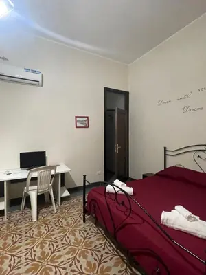 a bedroom with a bed and a desk with a computer at Maya Palace Real Rooms Palermo centre close to Cathedral in Palermo