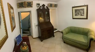 a living room with a chair and a grandfather clock at La Giara in Palermo