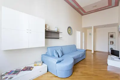 a living room with a blue couch and a tv at Quattro canti luxury apartment in Palermo