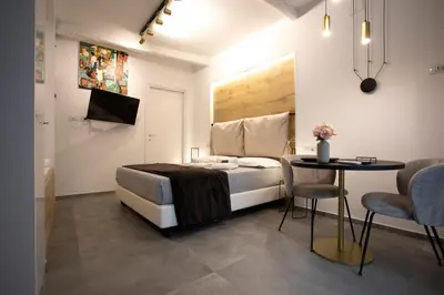 a bedroom with a bed and a table and chairs at LUXURY SUITE SANT ISIDORO in Palermo