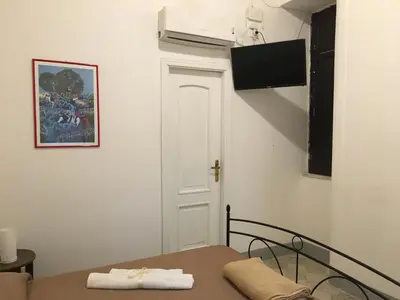 a small room with a bed and a white door at Le stanze di Regina Margherita in Palermo
