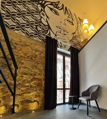a living room with a painting of a woman on the wall at Sant'Andrea - Luxury Rooms in Vucciria in Palermo