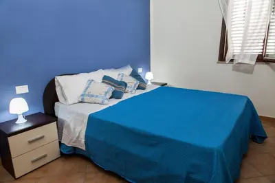 a blue bedroom with a bed with a blue wall at Casa vacanze Biondo in Trappeto