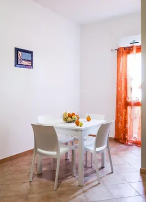 a white table with chairs and a bowl of fruit on it at Casa vacanze Biondo in Trappeto