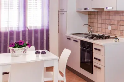a kitchen with a white table and a stove top oven at Casa vacanze Biondo in Trappeto