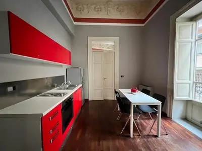 a kitchen with red cabinets and a table with chairs at 38,VELASQUEZ in Palermo