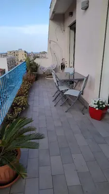 a balcony with chairs and a table on a building at La terrazza sul Castello in Palermo