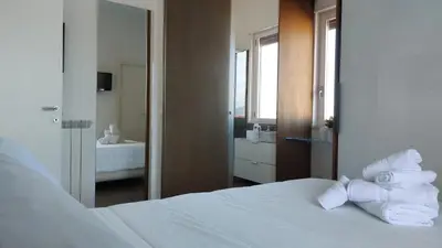 a bedroom with a white bed with towels on it at La terrazza sul Castello in Palermo
