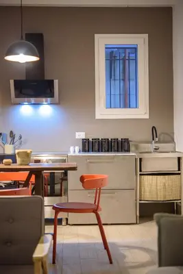 a kitchen with a table and a chair and a table at Suite Gharraf Palermo Old Town in Palermo