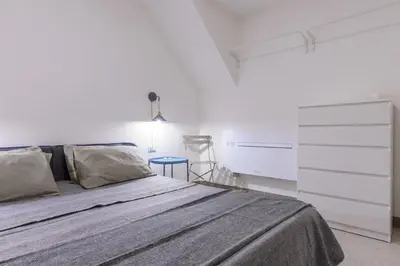 a white bedroom with a bed and a dresser at Suite Gharraf Palermo Old Town in Palermo