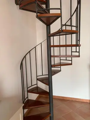 a metal spiral staircase in a room with a wall at Palazzo resuttana in Palermo