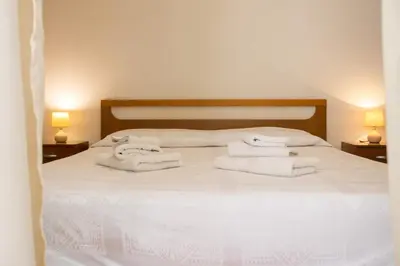 a bedroom with a white bed with towels on it at Hola House al Capo in Palermo