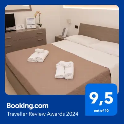 a hotel room with two towels on a bed at Piave77 in Bagheria