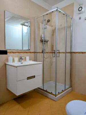 a bathroom with a glass shower and a sink at Piave77 in Bagheria