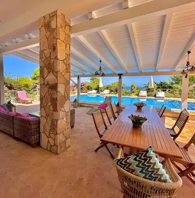 a white house with stairs and a palm tree at Stunning Seafront Villa in Scopello Pool & Jacuzzi in Scopello