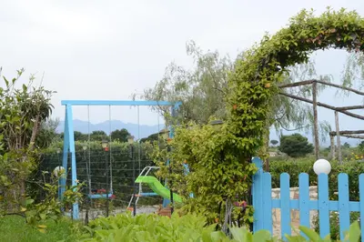 a garden with a playground in the background at Holiday Homes in Campofelice di Roccella