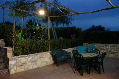 a table and chairs on a patio at night at Holiday Homes in Campofelice di Roccella