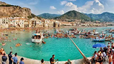 a group of people in the water at a beach at Holiday Homes in Campofelice di Roccella