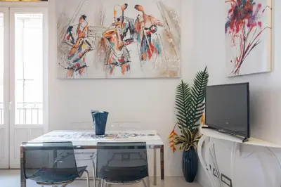 a room with a table with two chairs and a tv at Suite San Sebastiano by DomuSicily in Palermo