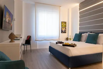 a bedroom with a bed and a desk in a room at La Musa Apartments & Rooms in Palermo