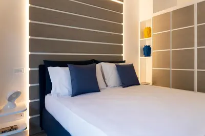 a bedroom with a bed with blue and white pillows at La Musa Apartments & Rooms in Palermo