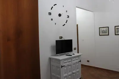 a room with a tv on a white wall at Himera Holiday in Palermo