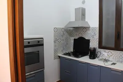 a kitchen with blue cabinets and a stove top oven at Himera Holiday in Palermo