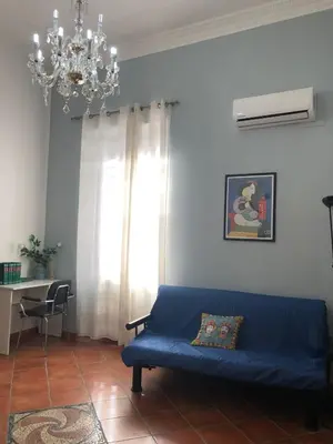 a blue couch in a living room with a chandelier at Himera Holiday in Palermo