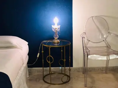 a candle on a table with a chair next to a bed at B&B Al Piazza Marina in Palermo