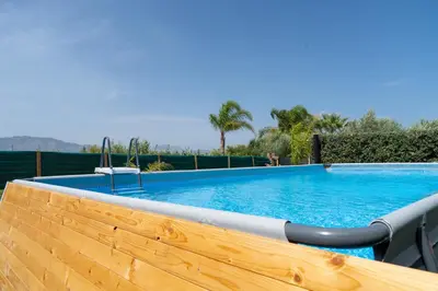 a large swimming pool with a wooden fence and a wooden at Garden Voyages Balestrate in Balestrate