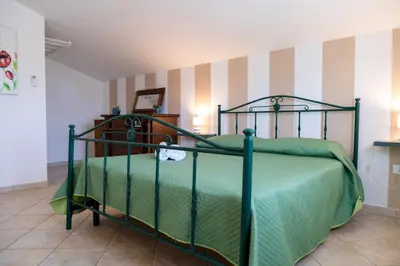 a bedroom with a bed with a green bedspread at Garden Voyages Balestrate in Balestrate
