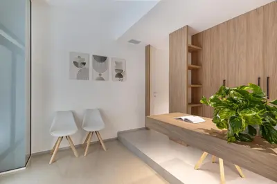a dining room with a wooden table and two chairs at Ideal Residence & SPA in Alcamo