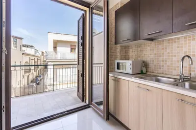 a kitchen with a view of a balcony at Ideal Residence & SPA in Alcamo