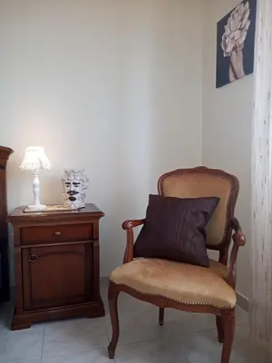 a chair with a pillow on it next to a table at Lorenzo Guest Suite - Garage privato in Palermo