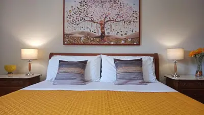 a bedroom with a bed with two lamps and a painting at Lorenzo Guest Suite - Garage privato in Palermo