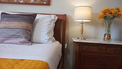 a bed with a lamp and a vase of flowers on a night stand at Lorenzo Guest Suite - Garage privato in Palermo