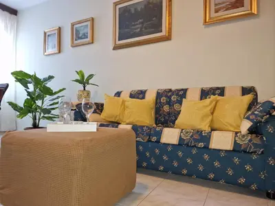 a living room with a couch with yellow pillows and a table at Lorenzo Guest Suite - Garage privato in Palermo