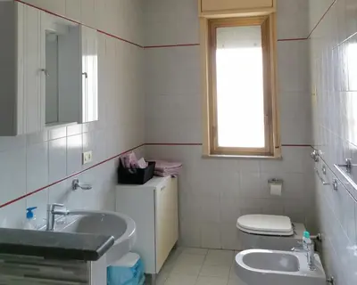 a bathroom with a sink and a toilet and a window at Lorenzo Guest Suite - Garage privato in Palermo