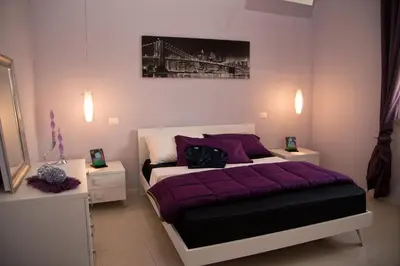 a bedroom with a purple bed with two night stands at La Conchiglia Case Vacanze in Balestrate