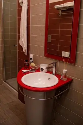 a bathroom with a red sink and a mirror at La Conchiglia Case Vacanze in Balestrate