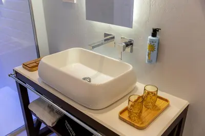 a bathroom sink on a counter with two glasses on it at Costamante Suites & Spa in Castellammare del Golfo
