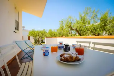 a table with a plate of food and orange juice at Casale la Macina Residence Scopello in Scopello