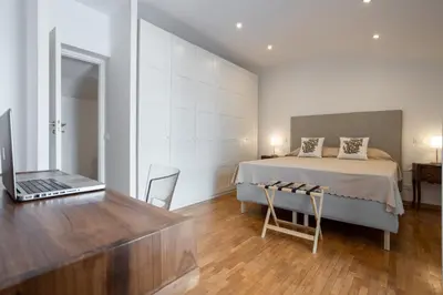 a bedroom with a bed and a desk with a laptop at Politeama rooftop in Palermo