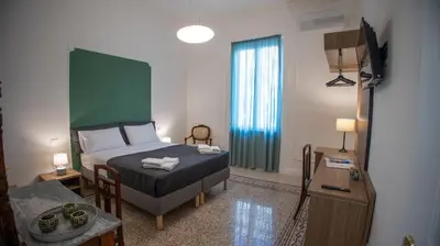 a bedroom with a bed and a television in it at Petrarca Suite in Palermo