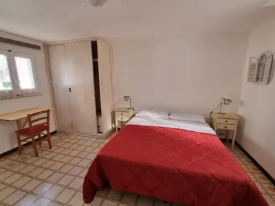 a bedroom with a red bed and a desk at Piazza Politeama in Palermo